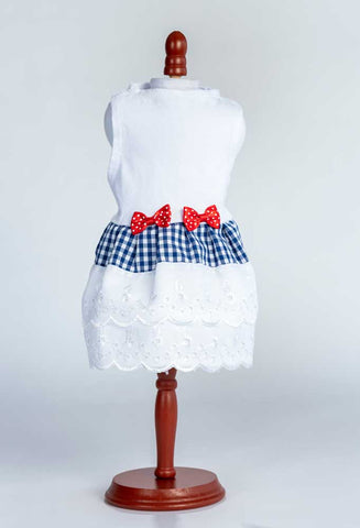 An adorable, one-of-a-kind white top with gingham and eyelet skirt and bow trim for your dog.